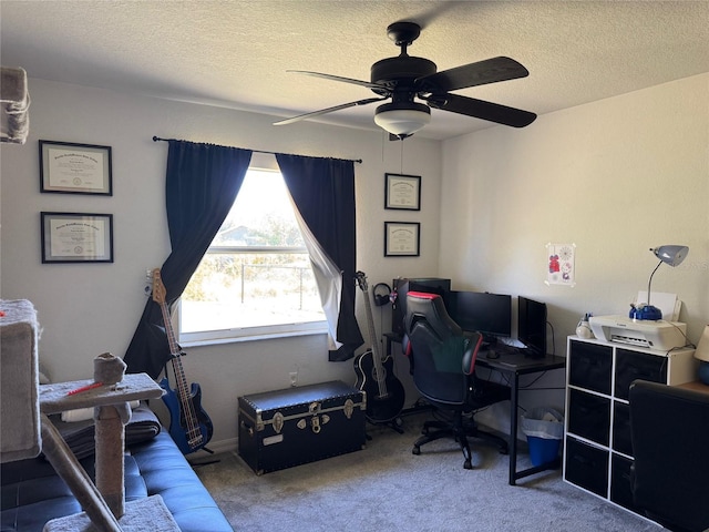 office space featuring carpet floors, a ceiling fan, and a textured ceiling