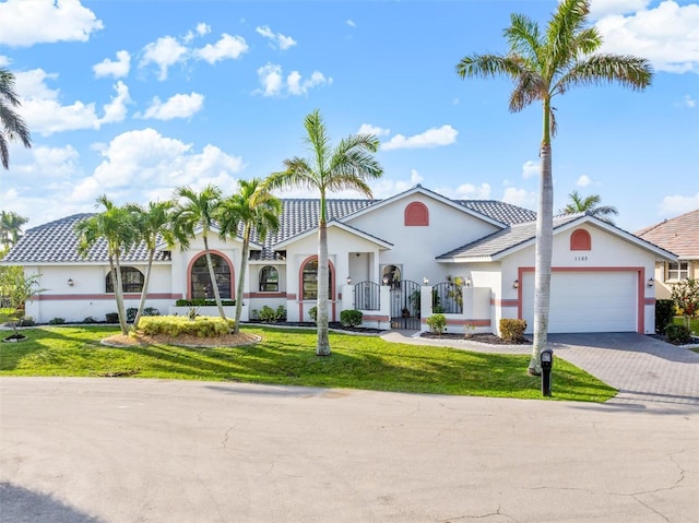 mediterranean / spanish house with a garage and a front yard