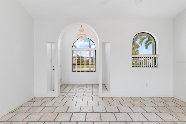 unfurnished room with an inviting chandelier