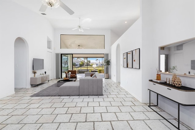 interior space with ceiling fan and a high ceiling