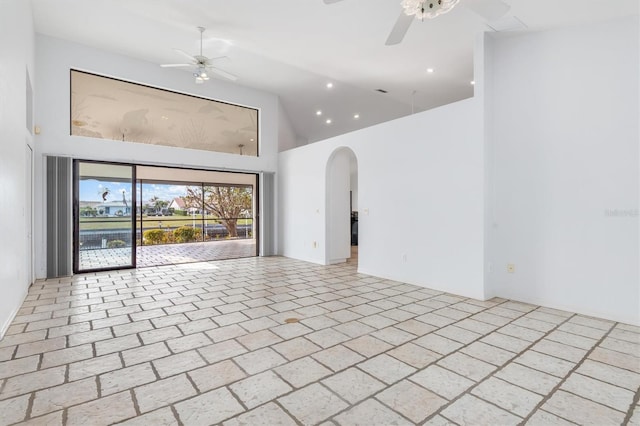 unfurnished room featuring ceiling fan and a towering ceiling