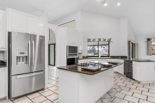 kitchen featuring appliances with stainless steel finishes, white cabinetry, high vaulted ceiling, kitchen peninsula, and dark stone counters