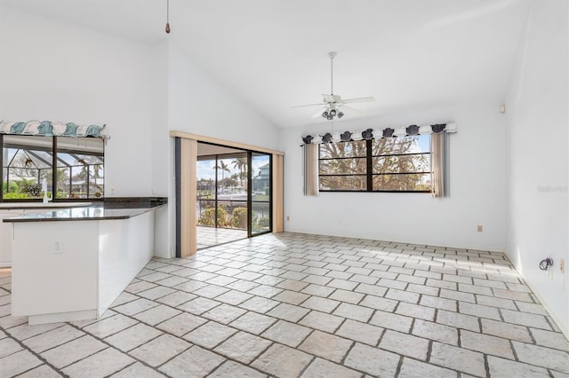 unfurnished dining area featuring high vaulted ceiling and ceiling fan