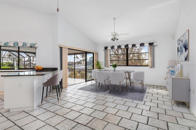 dining space with high vaulted ceiling and ceiling fan