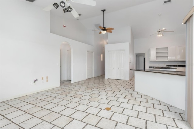 kitchen featuring ceiling fan, white cabinets, and high vaulted ceiling