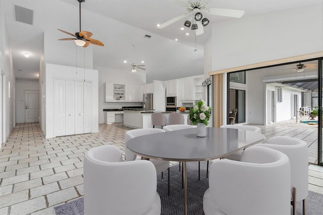 dining area featuring high vaulted ceiling and ceiling fan