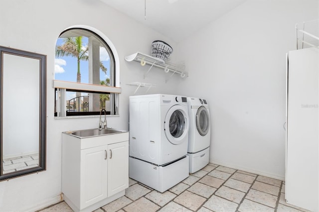 laundry room featuring cabinets, washing machine and clothes dryer, and sink