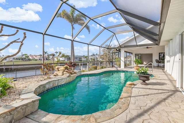 view of swimming pool with a lanai, a patio, ceiling fan, and a water view