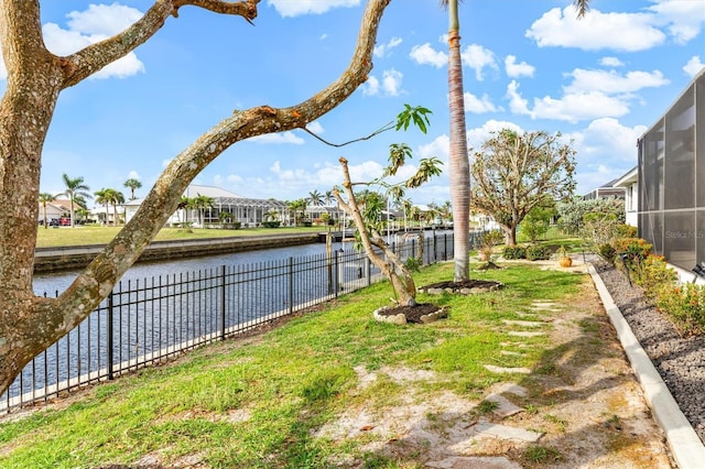 view of yard featuring a water view and a sunroom