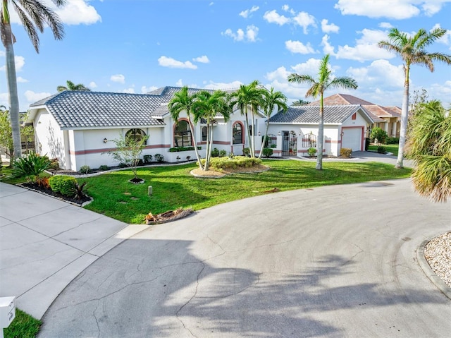 mediterranean / spanish-style home with a garage and a front yard