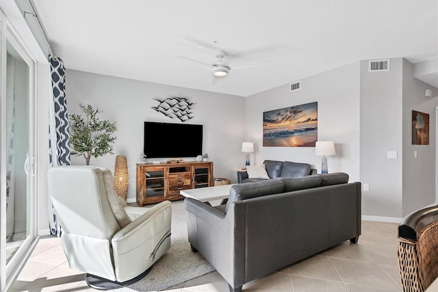 living area featuring ceiling fan, visible vents, light tile patterned floors, and baseboards