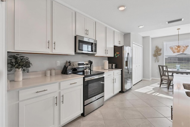 kitchen with light countertops, hanging light fixtures, stainless steel appliances, and white cabinetry