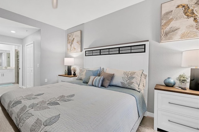 bedroom featuring baseboards, ensuite bath, and a closet