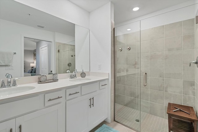 ensuite bathroom featuring double vanity, visible vents, connected bathroom, and a sink