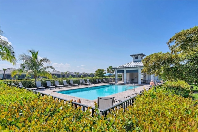 community pool with fence and a patio