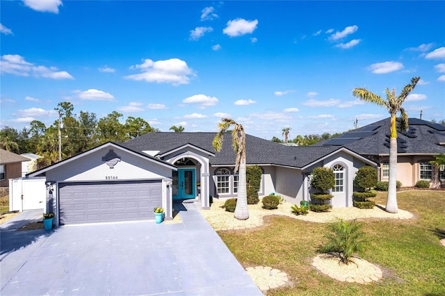 single story home featuring a garage and a front yard