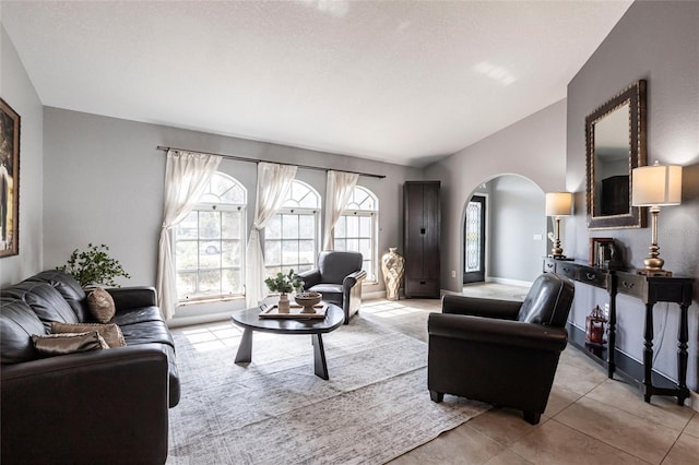 tiled living room featuring vaulted ceiling