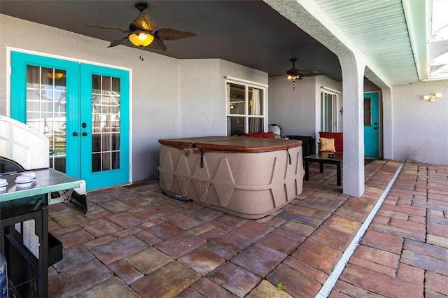 view of patio / terrace with a hot tub, ceiling fan, and french doors