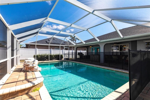 view of swimming pool featuring ceiling fan, a lanai, and a patio area