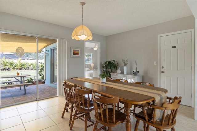 dining space featuring a textured ceiling, light tile patterned flooring, and a ceiling fan