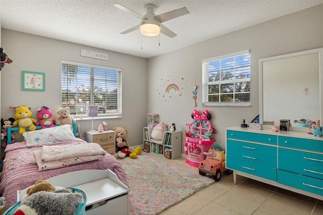 tiled bedroom featuring a textured ceiling, ceiling fan, and multiple windows