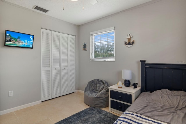 bedroom featuring a closet, visible vents, a textured ceiling, and baseboards