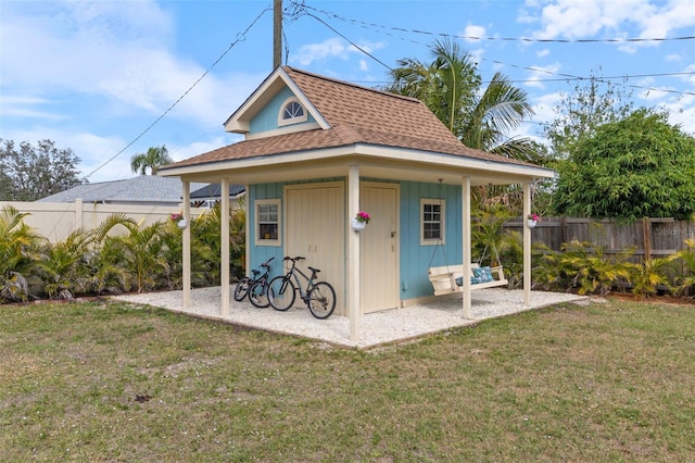 view of outbuilding featuring fence and an outbuilding