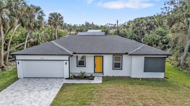 single story home featuring a garage and a front yard