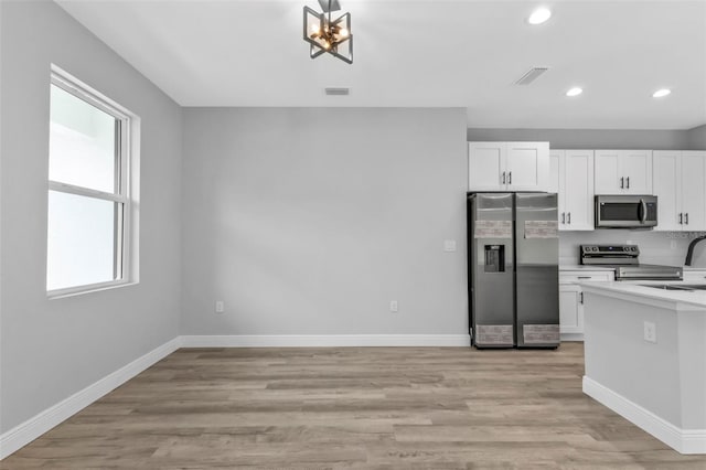 kitchen featuring stainless steel appliances, white cabinetry, sink, and light hardwood / wood-style flooring