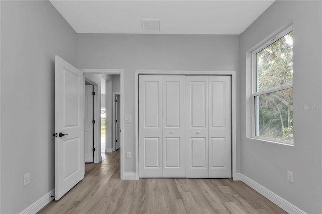 unfurnished bedroom featuring a closet and light wood-type flooring