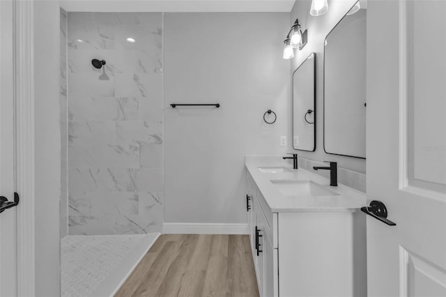 bathroom with vanity, hardwood / wood-style flooring, and tiled shower