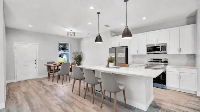 kitchen featuring white cabinetry, stainless steel appliances, and a kitchen island with sink