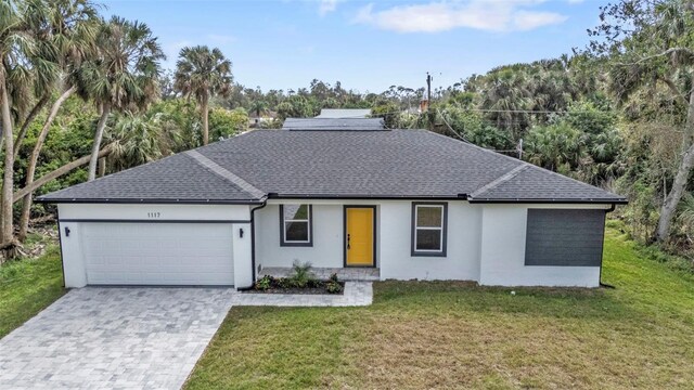 1117 Vernon Ave, Port Charlotte, FL 33948 - view of front facade with an attached garage, stucco siding, roof with shingles, decorative driveway, and a front lawn