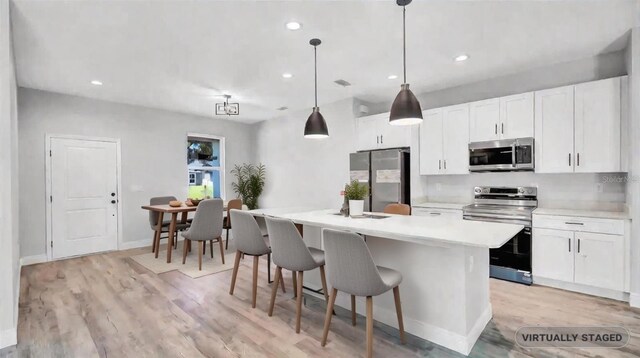 1117 Vernon Ave, Port Charlotte, FL 33948 - kitchen featuring stainless steel appliances, light wood-type flooring, light countertops, white cabinets, and recessed lighting