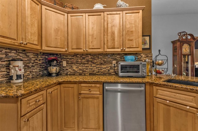 kitchen featuring tasteful backsplash, stainless steel dishwasher, sink, and dark stone countertops