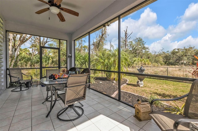 sunroom / solarium featuring a ceiling fan and outdoor dining space