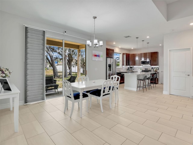 dining space featuring light tile patterned floors and an inviting chandelier