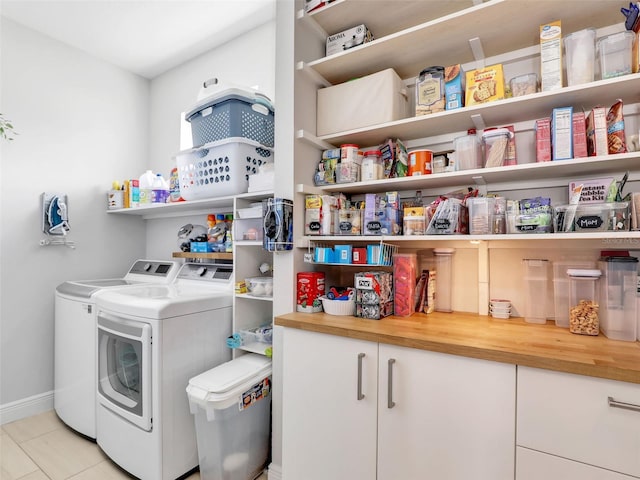 clothes washing area featuring separate washer and dryer and light tile patterned floors