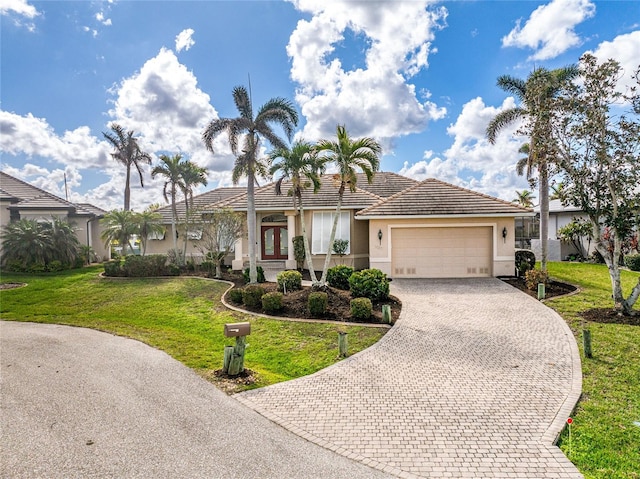 ranch-style home featuring a garage and a front yard