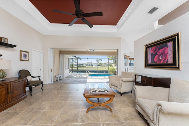 living room featuring crown molding, ceiling fan, and a tray ceiling