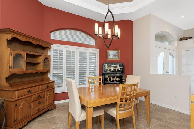 dining area featuring an inviting chandelier, ornamental molding, a raised ceiling, and light tile patterned floors