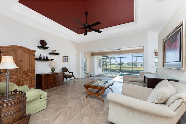 living room featuring a raised ceiling and ceiling fan