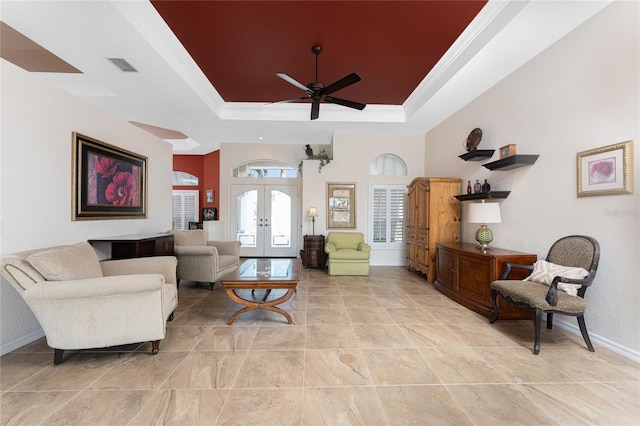 living room featuring french doors, ceiling fan, crown molding, and a raised ceiling