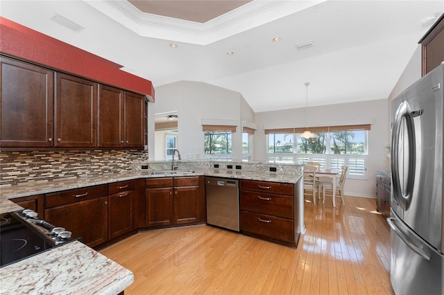 kitchen featuring stainless steel appliances, sink, hanging light fixtures, kitchen peninsula, and a healthy amount of sunlight