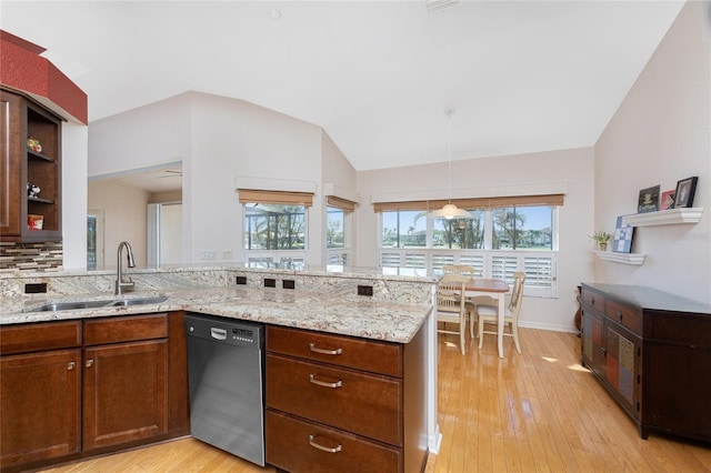 kitchen with lofted ceiling, sink, light hardwood / wood-style flooring, dishwasher, and kitchen peninsula