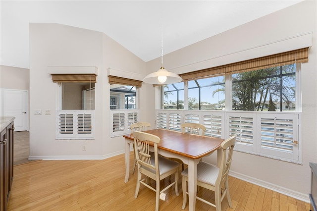 dining area featuring lofted ceiling, a healthy amount of sunlight, and light wood-type flooring