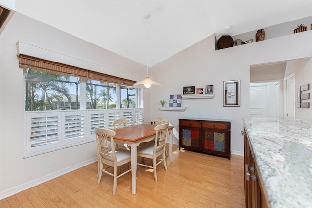 dining area featuring light hardwood / wood-style flooring and high vaulted ceiling