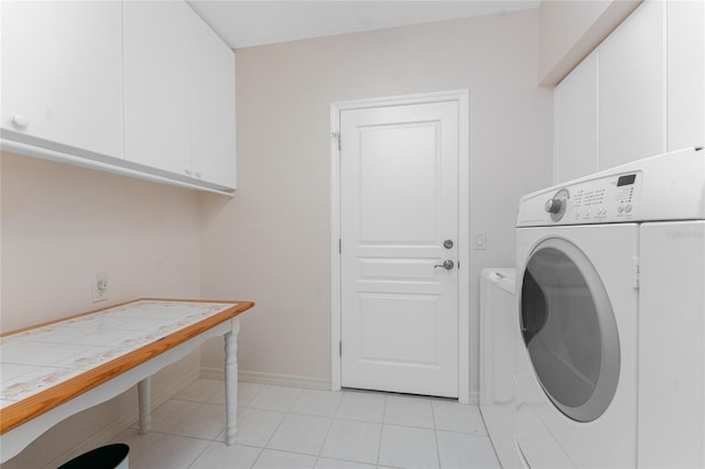 laundry area with light tile patterned floors, cabinets, and independent washer and dryer