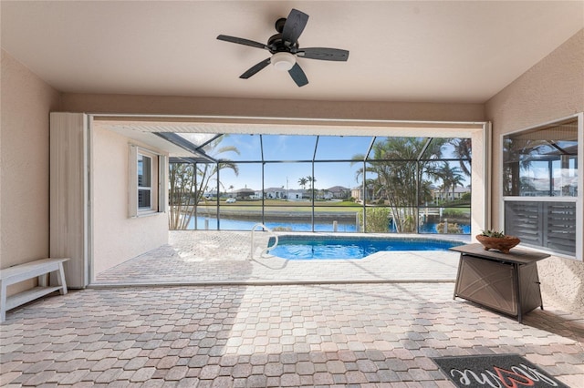 view of swimming pool with a lanai, a patio, ceiling fan, and a water view