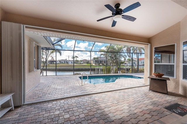 view of pool with a water view, ceiling fan, a lanai, and a patio area